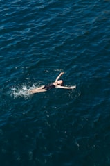 woman in black bikini swimming in blue water
