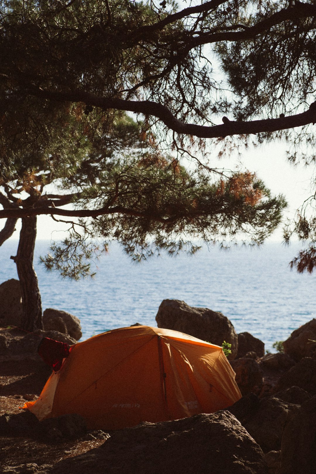 orange tent near body of water during daytime