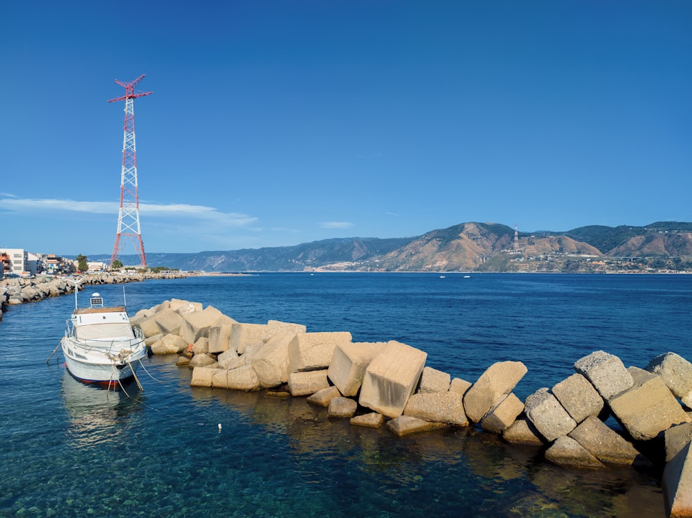 white and red windmill near body of water during daytime