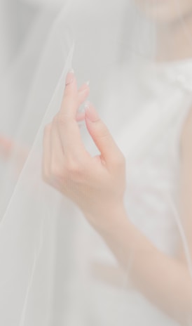 woman in white dress holding white textile