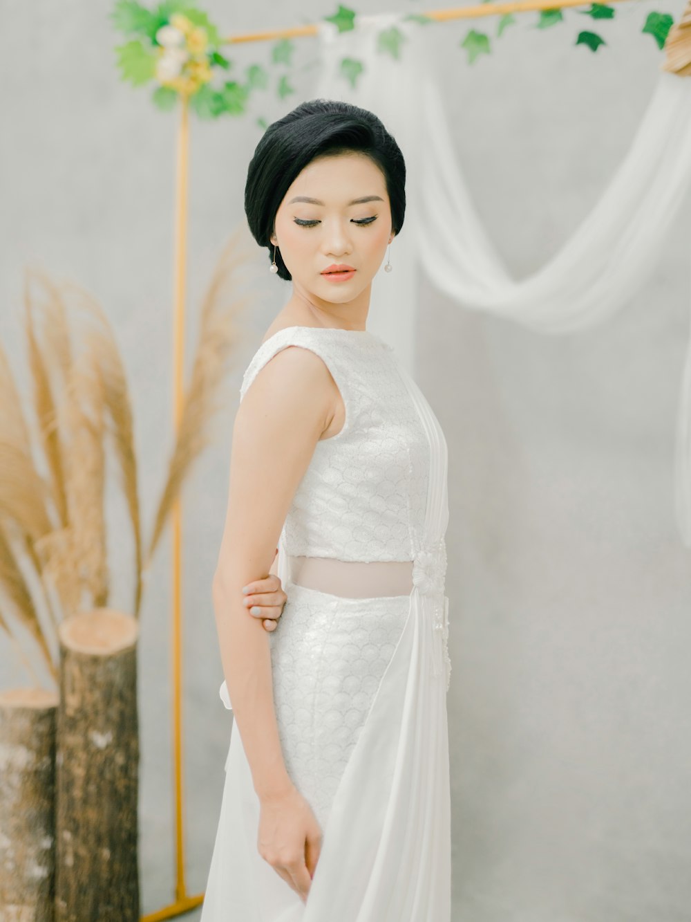 woman in white sleeveless dress standing beside brown tree