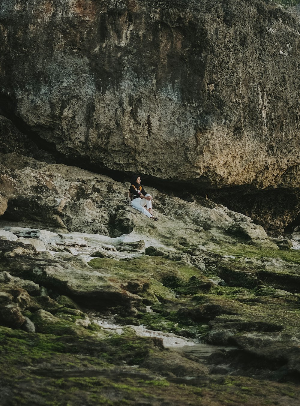 woman in white dress sitting on rock