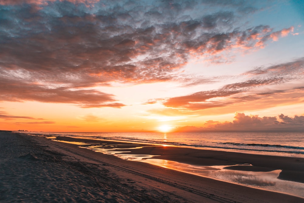 Grauer Sand unter bewölktem Himmel bei Sonnenuntergang