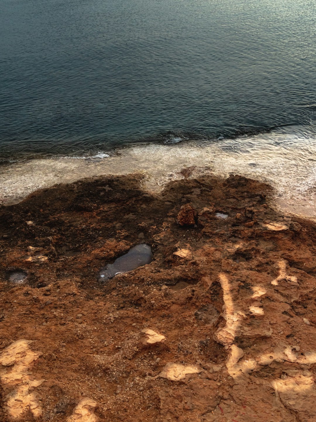 brown rock formation on body of water during daytime