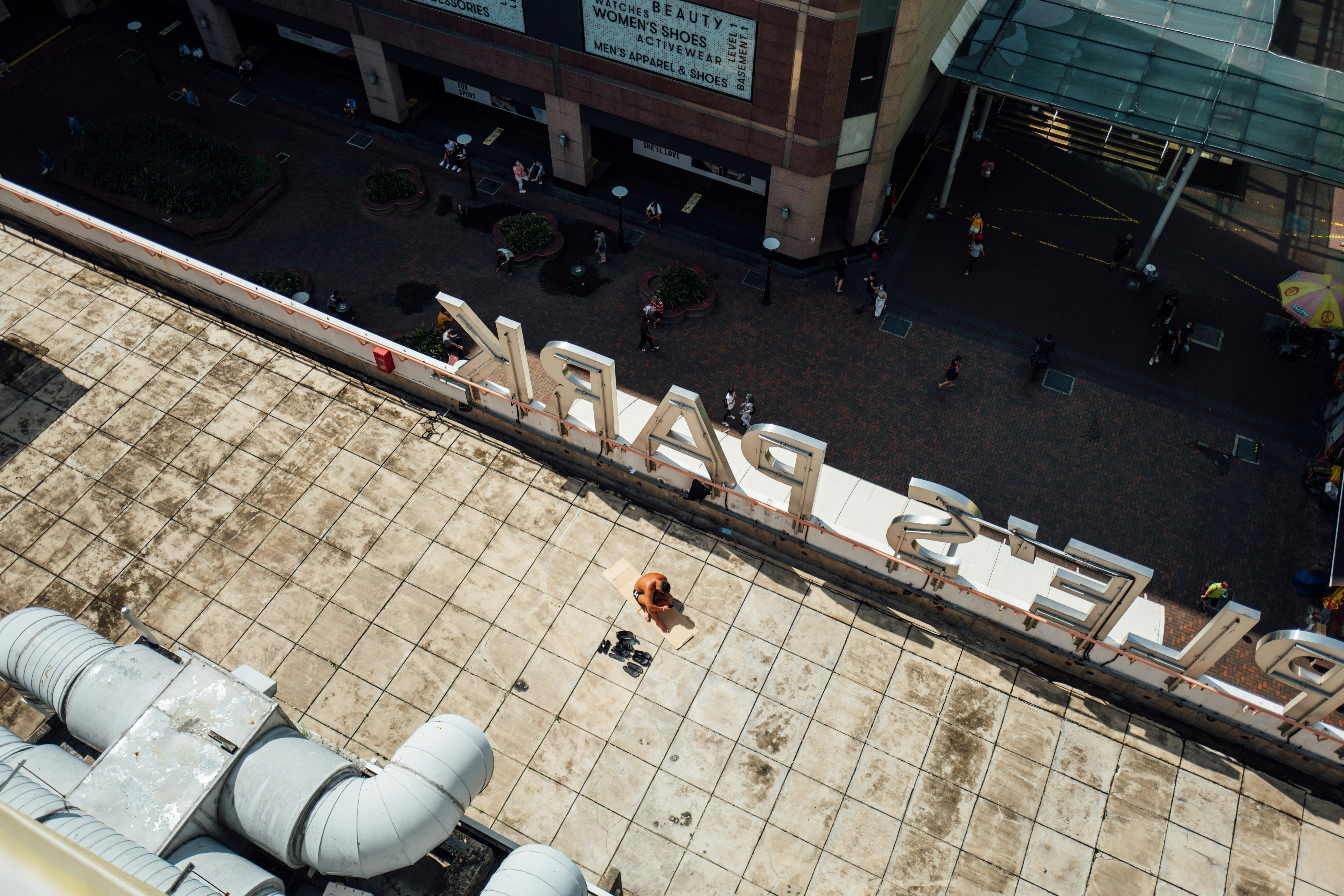 A person practices yoga on a sunlit tiled rooftop.