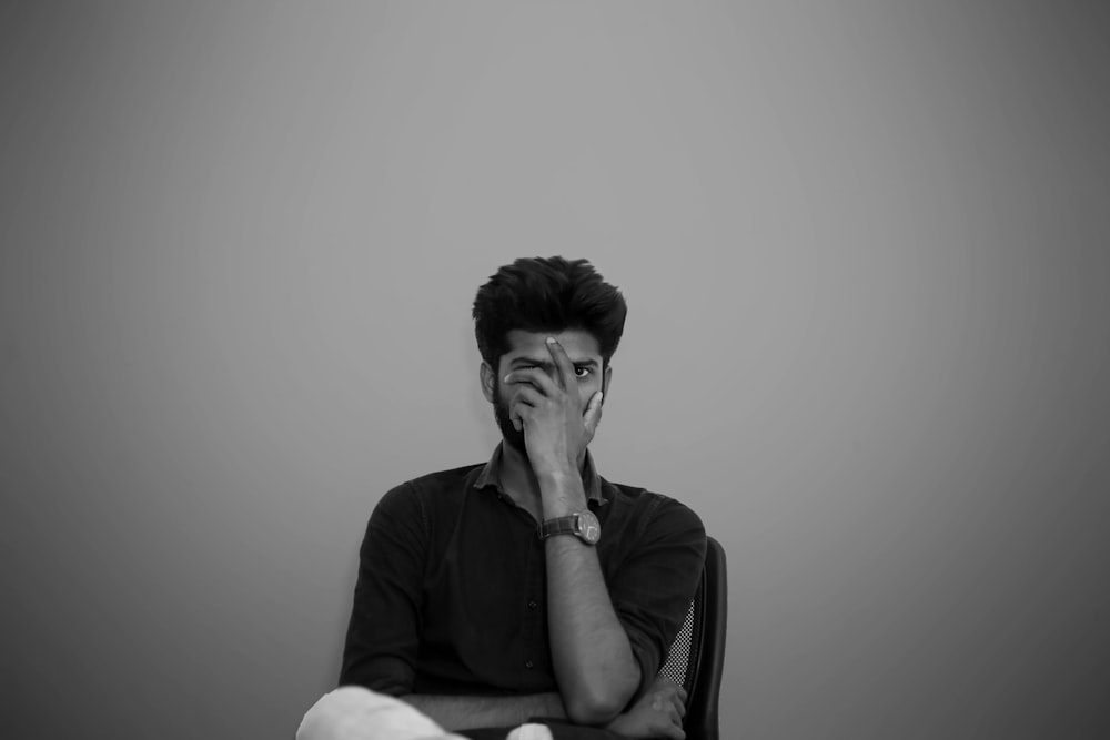 a black and white photo of a man sitting in a chair