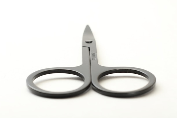 A pair of stainless steel scissors with ergonomic handles displayed on a white background.