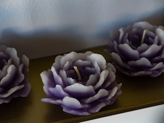 A vibrant display of colorful candles arranged on a dark purple cloth with mystical symbols.