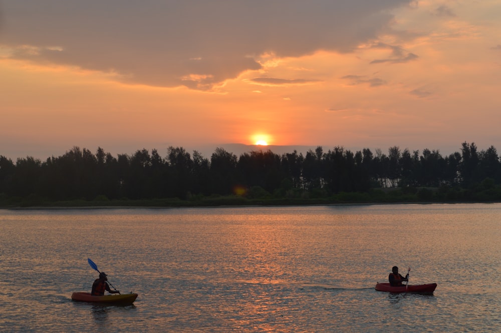 Silhouette von 2 Personen, die während des Sonnenuntergangs auf dem Boot fahren