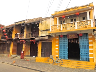 A vibrant street scene in Seville with colorful buildings and a rental bike parked nearby.
