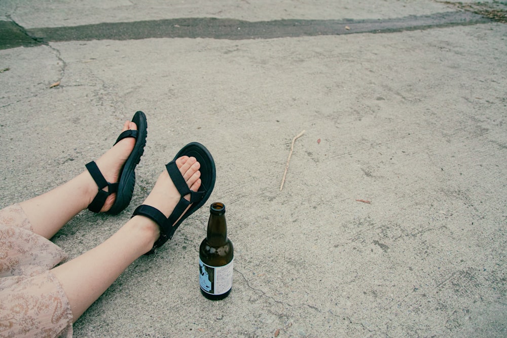 person wearing black sandals and black sandals