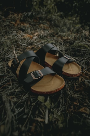 black and brown leather sandals on green grass