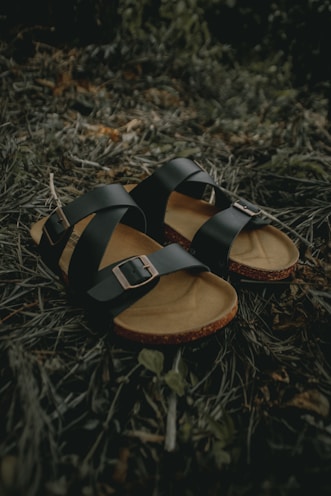 black and brown leather sandals on green grass