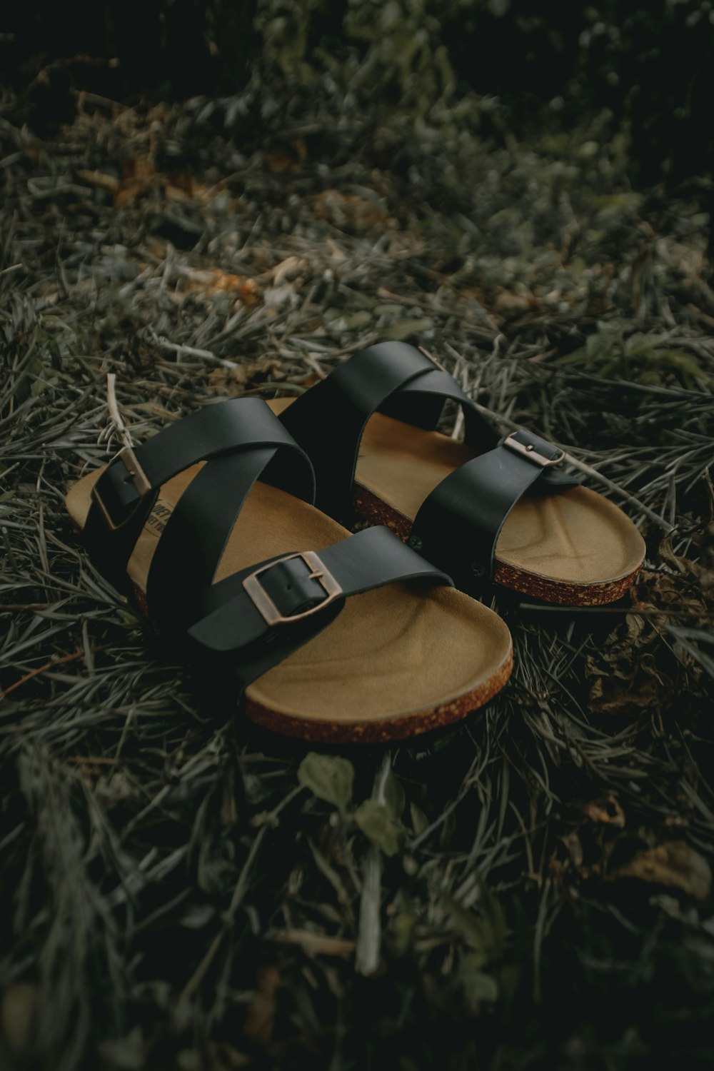black and brown leather sandals on green grass