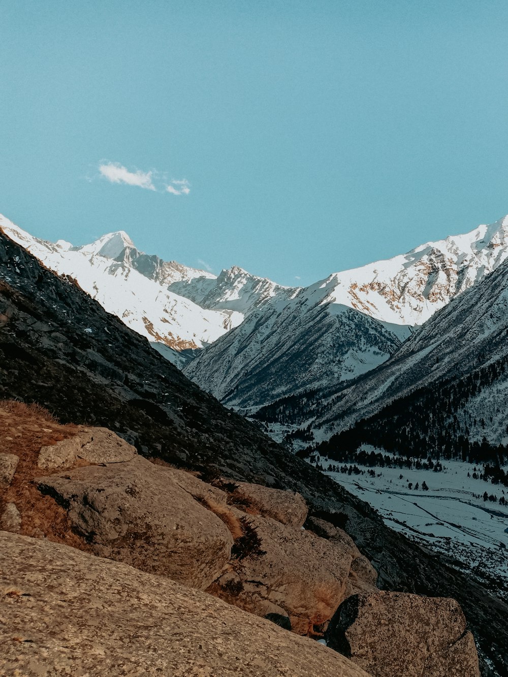 brown and white mountains near lake under blue sky during daytime