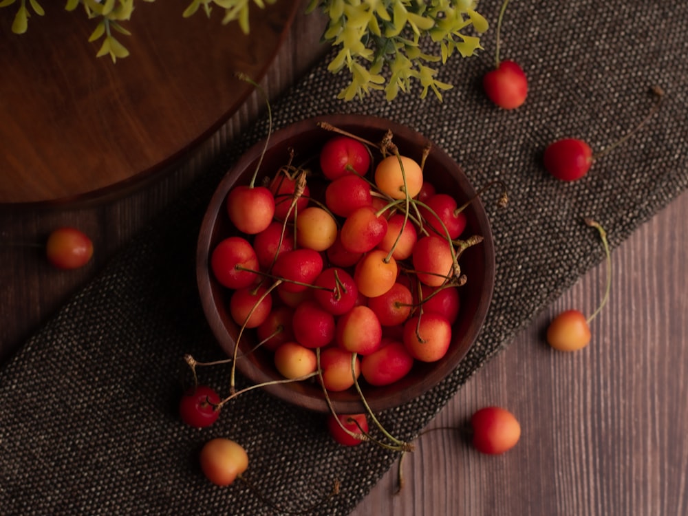 red and green round fruits on brown round bowl