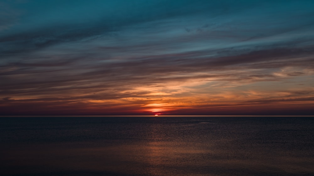 body of water under blue sky during sunset