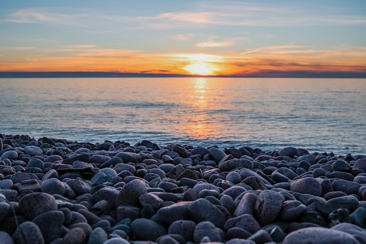 Lake Superior shoreline at sunset near Duluth Minnesota — rocky beach with golden light