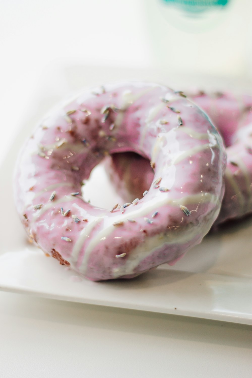 purple and white doughnut on white ceramic plate