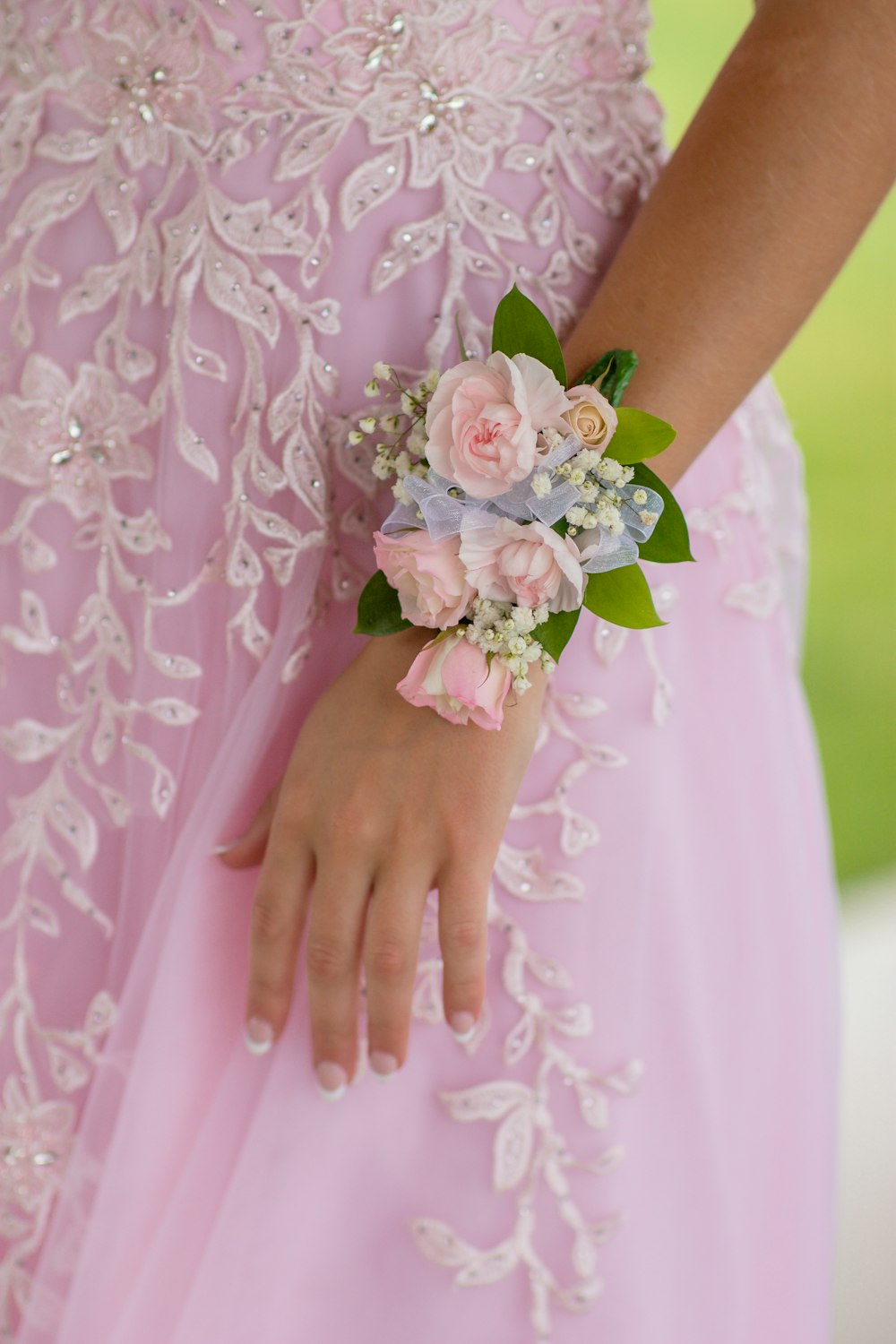 woman in pink floral dress holding white flower bouquet