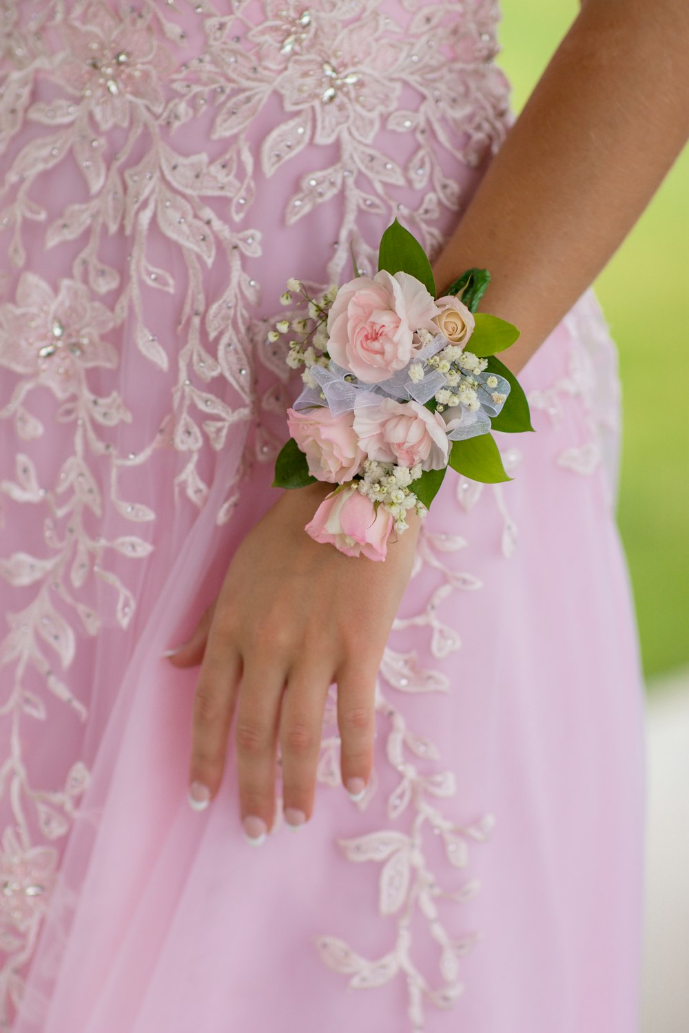 Mujer en vestido floral rosa sosteniendo ramo de flores blancas