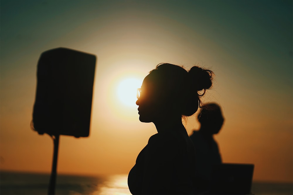 a woman standing in front of the sun