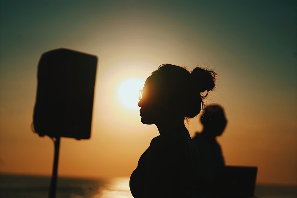 Una mujer parada frente al sol