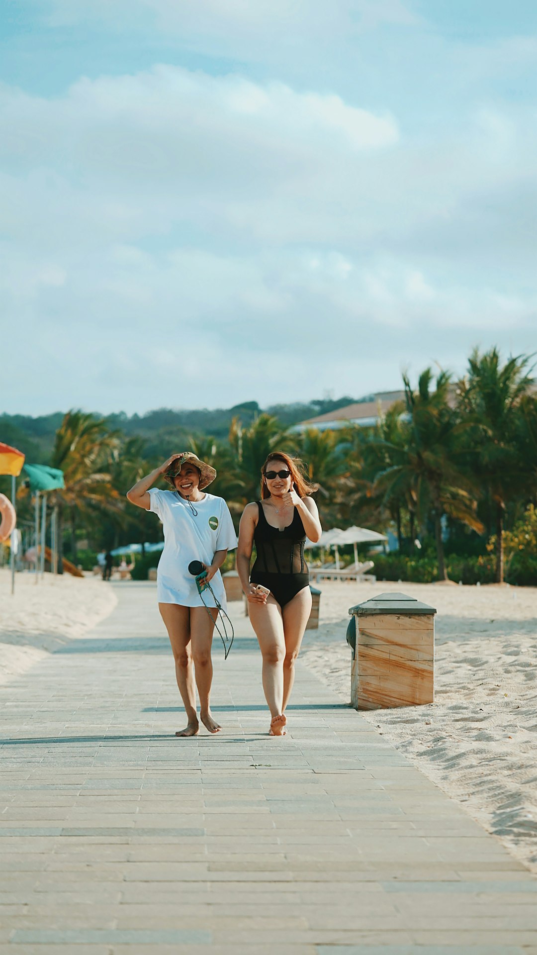 2 women standing on beach during daytime