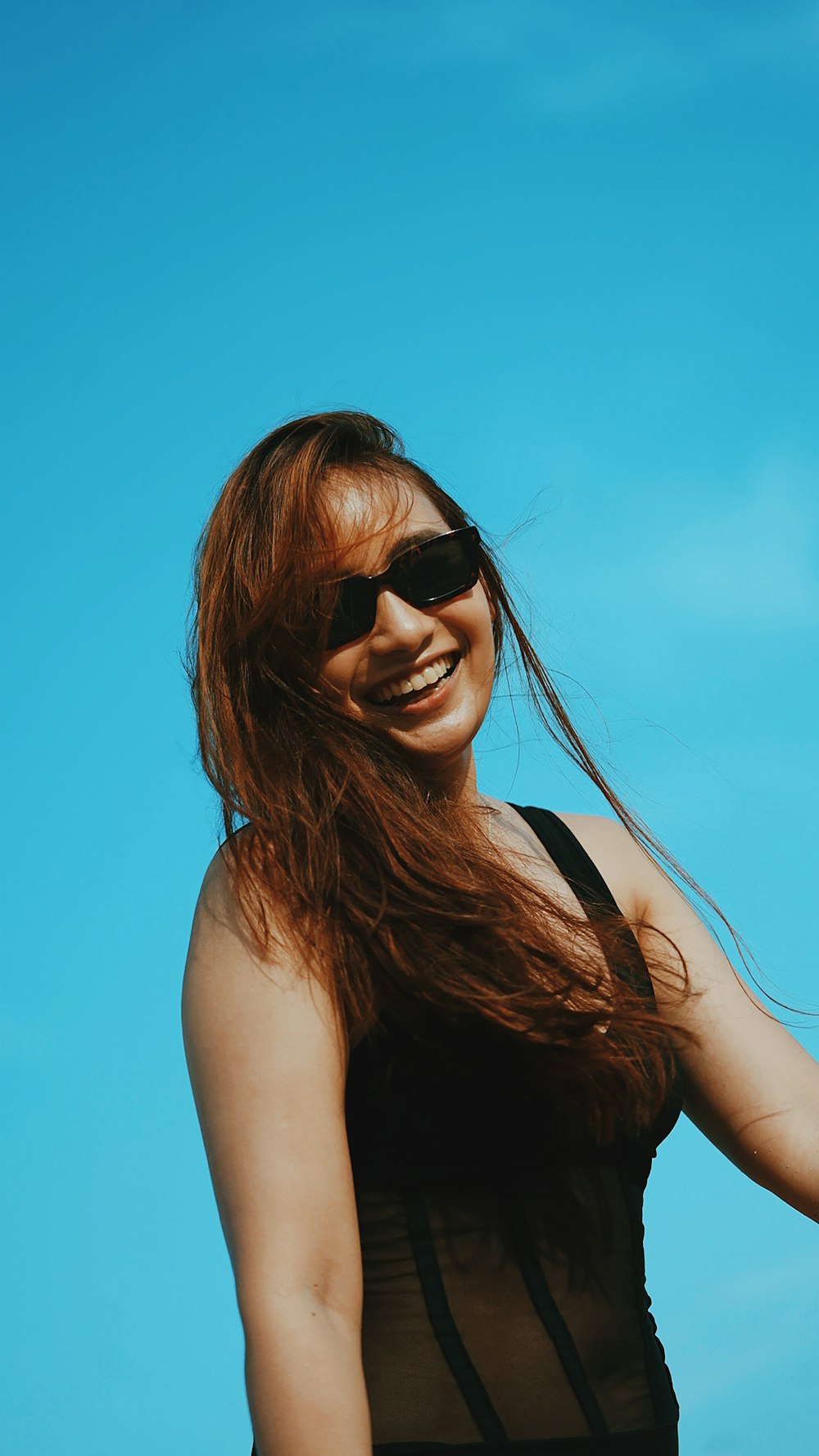 Frau in schwarzem Tanktop mit schwarzer Sonnenbrille