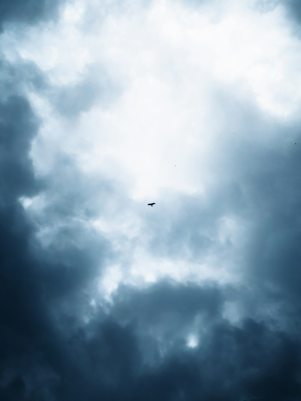 airplane flying under white clouds during daytime
