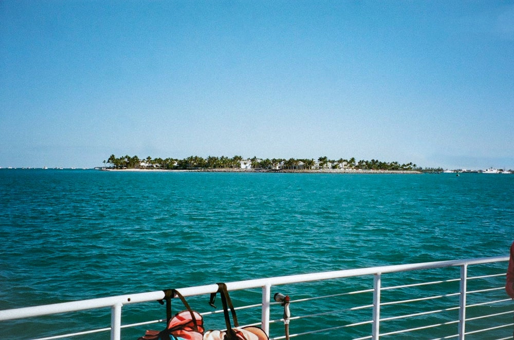 people sitting on red chair near body of water during daytime