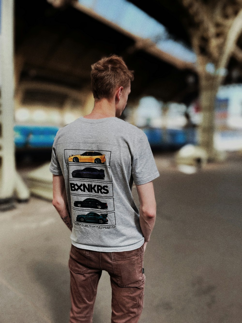 man in gray crew neck t-shirt and brown shorts standing on gray asphalt road during