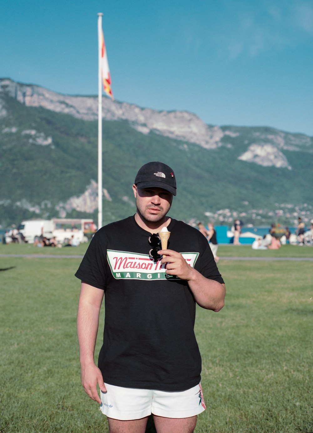 man in black crew neck t-shirt standing on green grass field during daytime