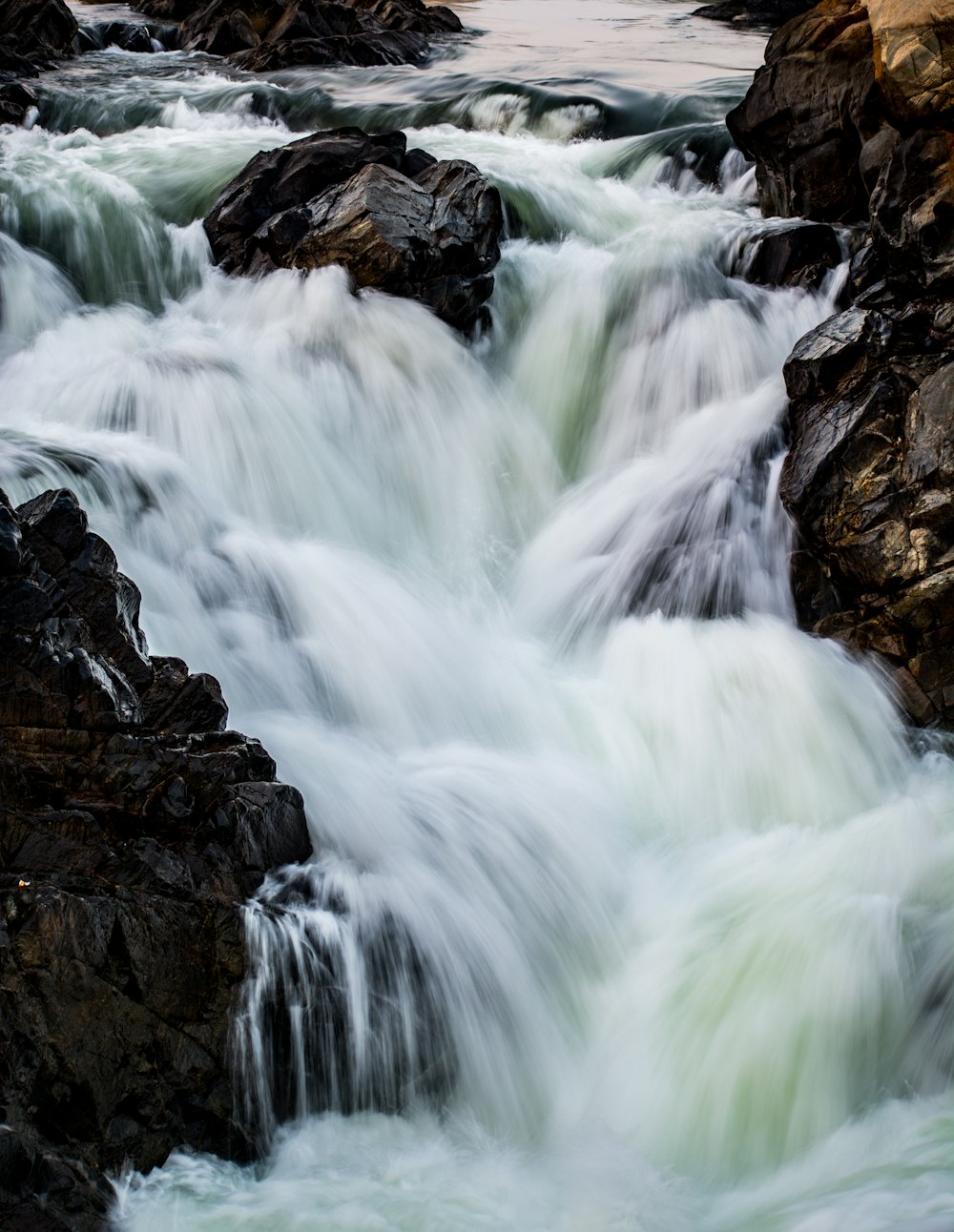 brown rock formation with water falls