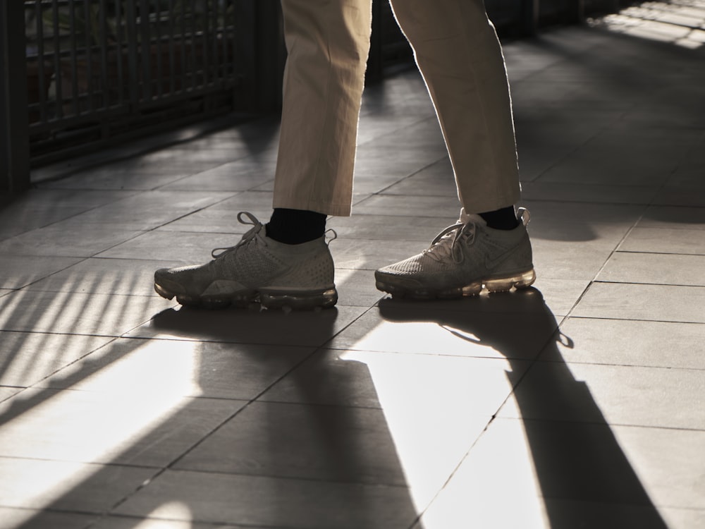 person in brown pants and black nike sneakers