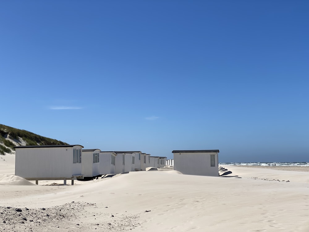 gray concrete houses on white sand during daytime