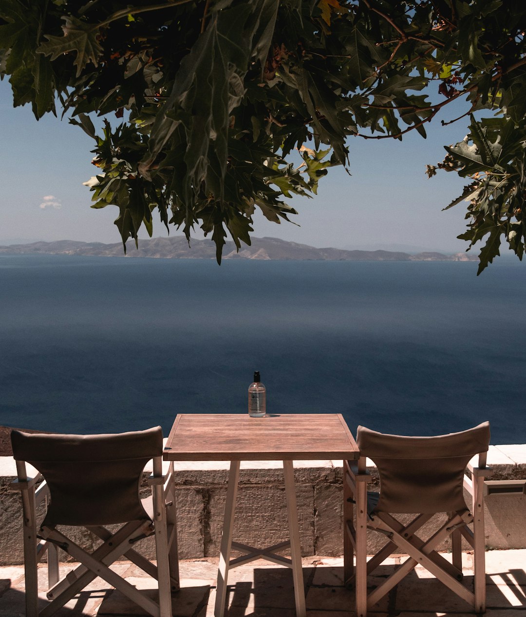 brown wooden table and chairs near sea during daytime