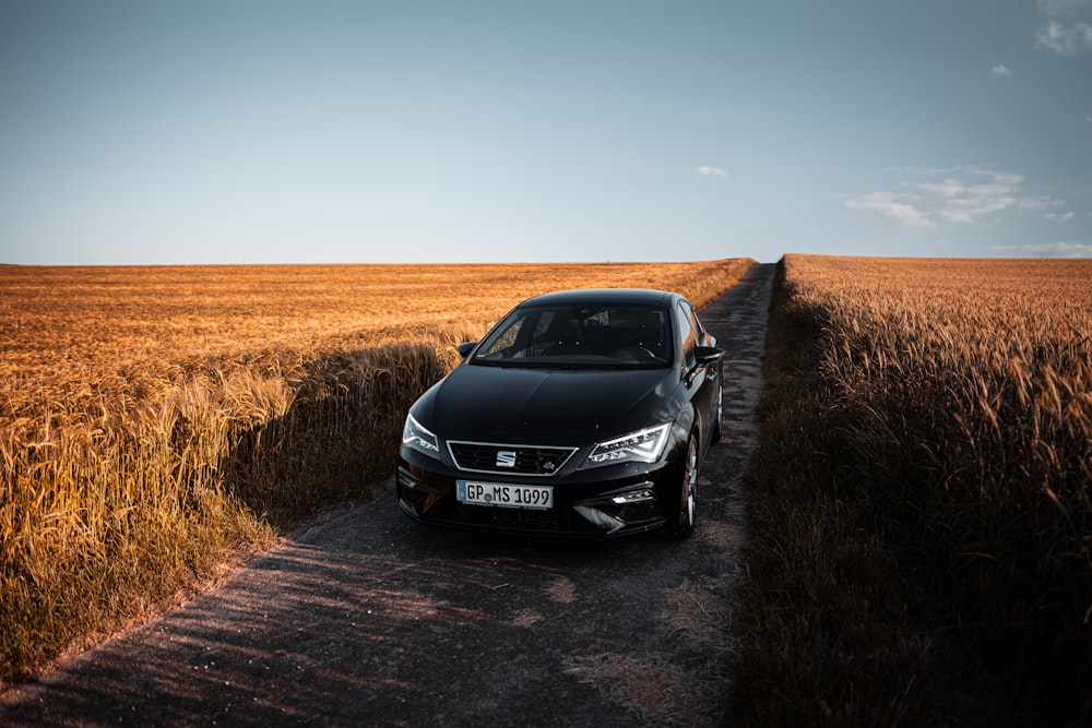 black mercedes benz c class on brown field during daytime