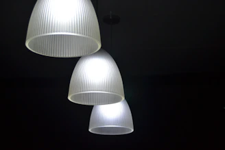 Close-up 3D image of modern pendant lights illuminating a dining area.