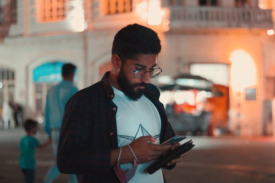 man in black jacket holding smartphone