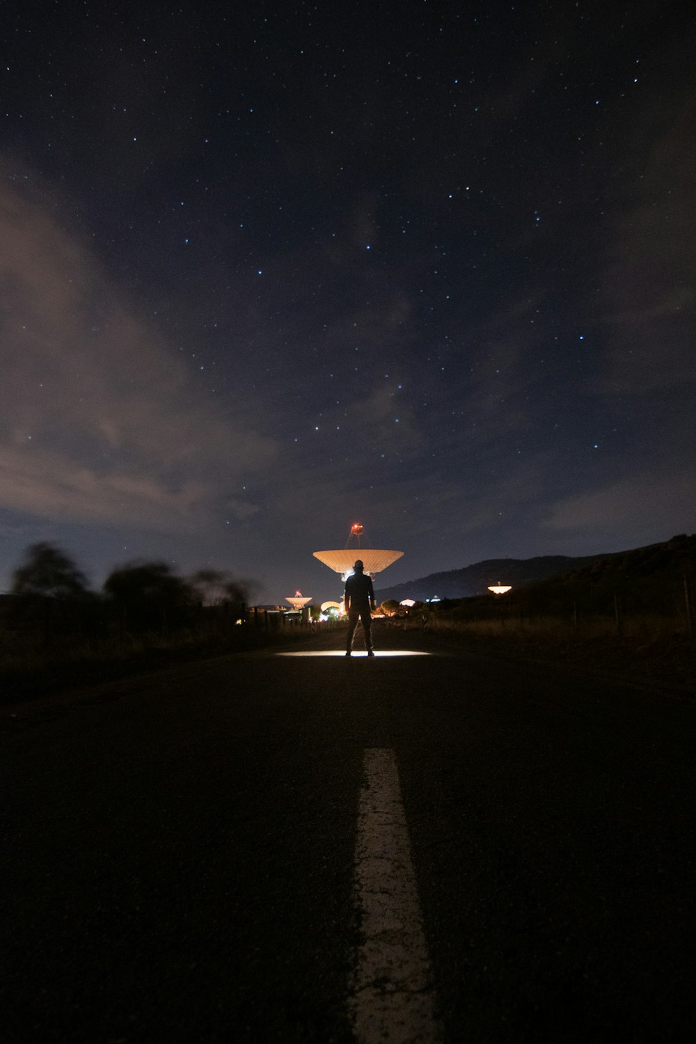 silhouette of person standing on road during night time