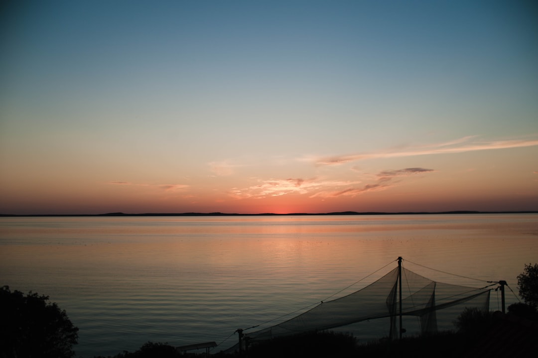 silhouette of bridge over the sea during sunset