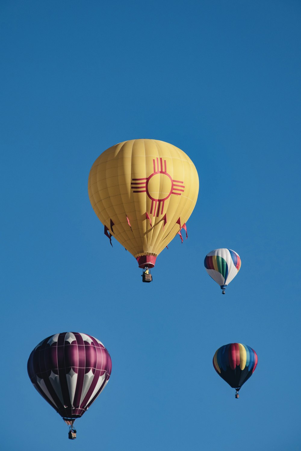 yellow hot air balloon in mid air under blue sky during daytime