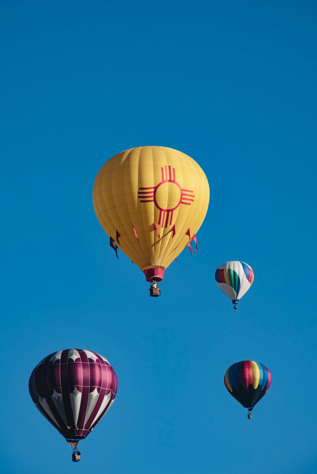 yellow hot air balloon in mid air under blue sky during daytime