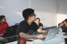 man in black crew neck t-shirt using macbook pro