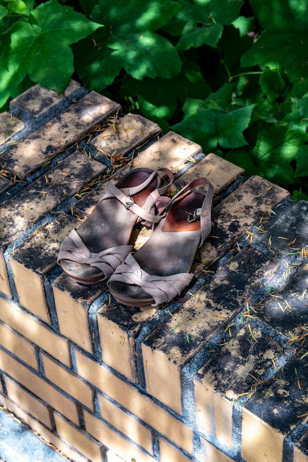 brown leather sandals on blue and white concrete floor