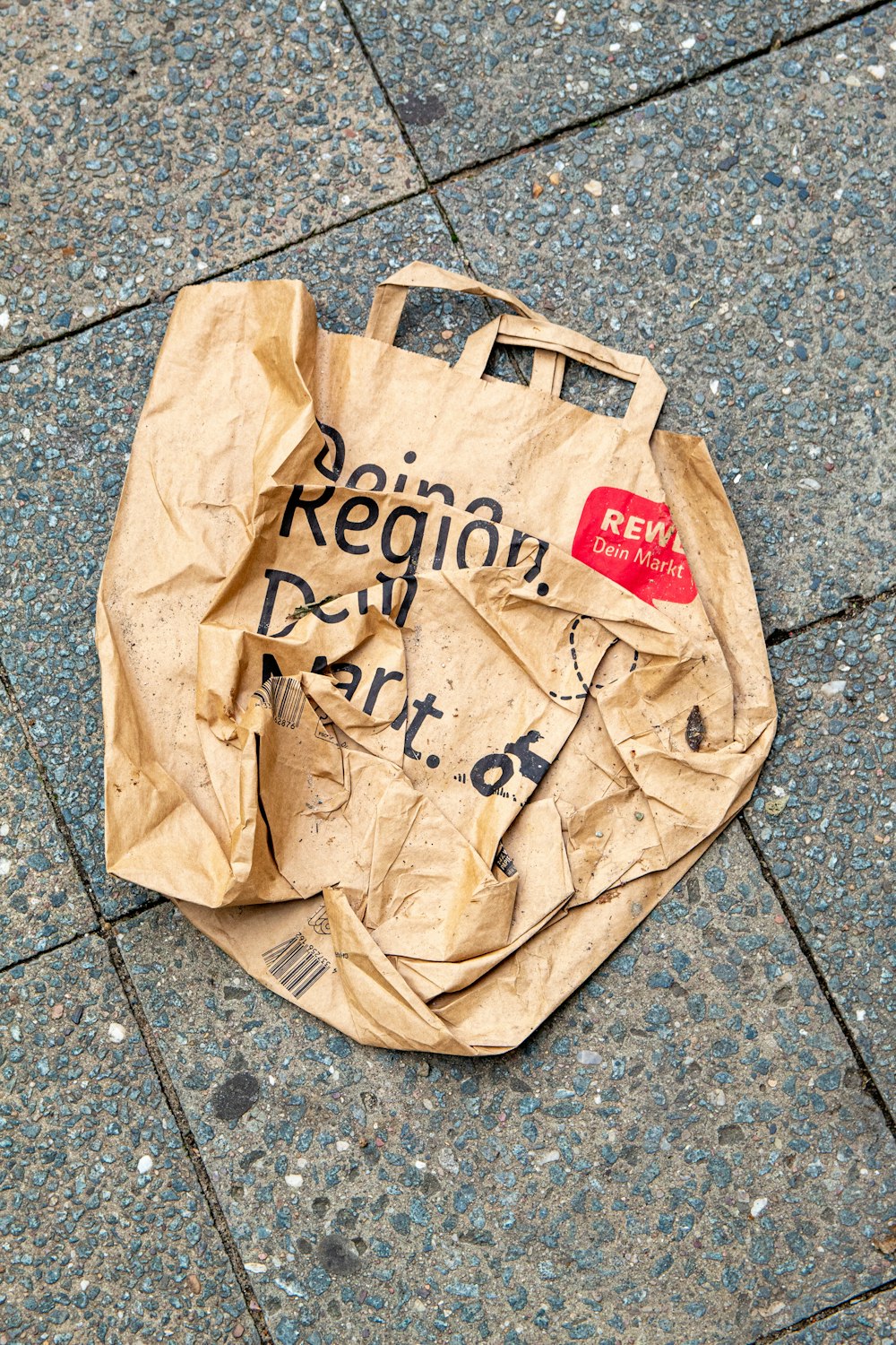 brown paper bag on gray floor tiles