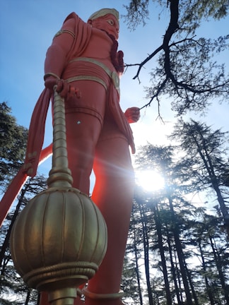 A powerful statue of Sun Go Kong holding the heavy golden staff in a dynamic pose.