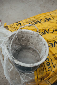 gray metal bucket on yellow paper