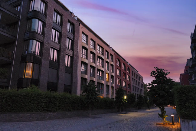 A serene residential street lined with stylish flats and soft evening light.